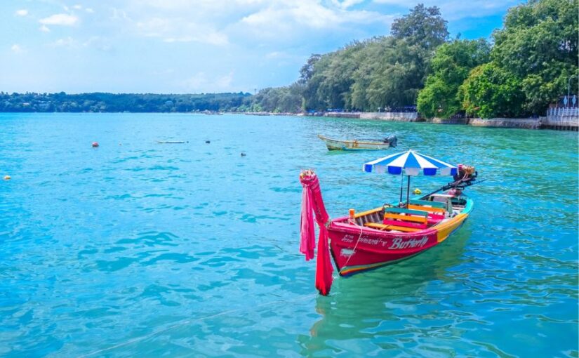 プーケット日本人ガイド同行ツアーで訪れる、透明度の高い海と伝統的なボートが並ぶ美しい海岸風景。