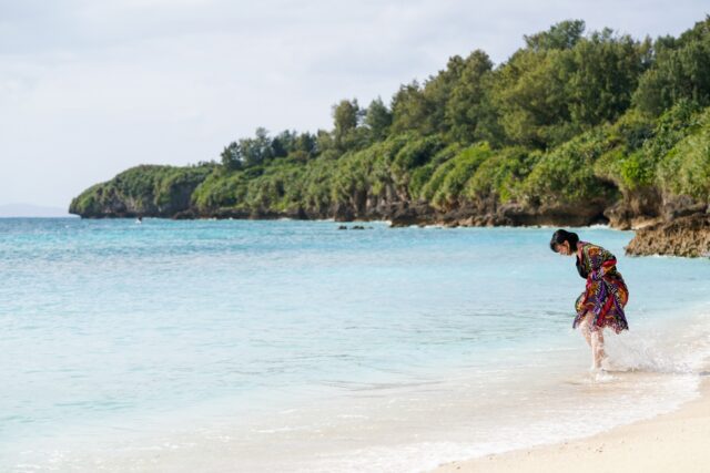 身着东方服饰的女子在清澈见底的海边与海浪嬉戏 旅行