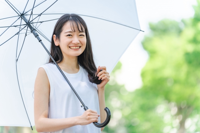 傘を持って雨季のプーケット旅行を楽しむ女性