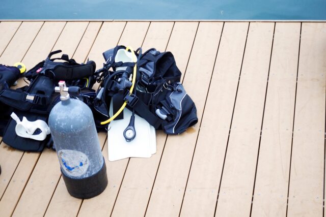 甲板上摆放的氧气瓶、浮力调节器(BCD)、脚蹼等潜水装备